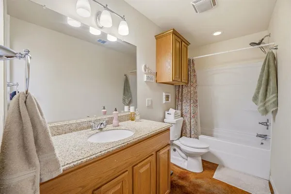 a bathroom with a granite countertop sink toilet and shower