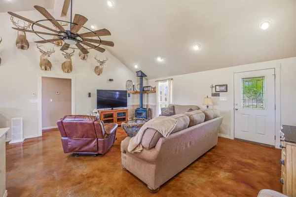 a living room with furniture a flat screen tv and a window
