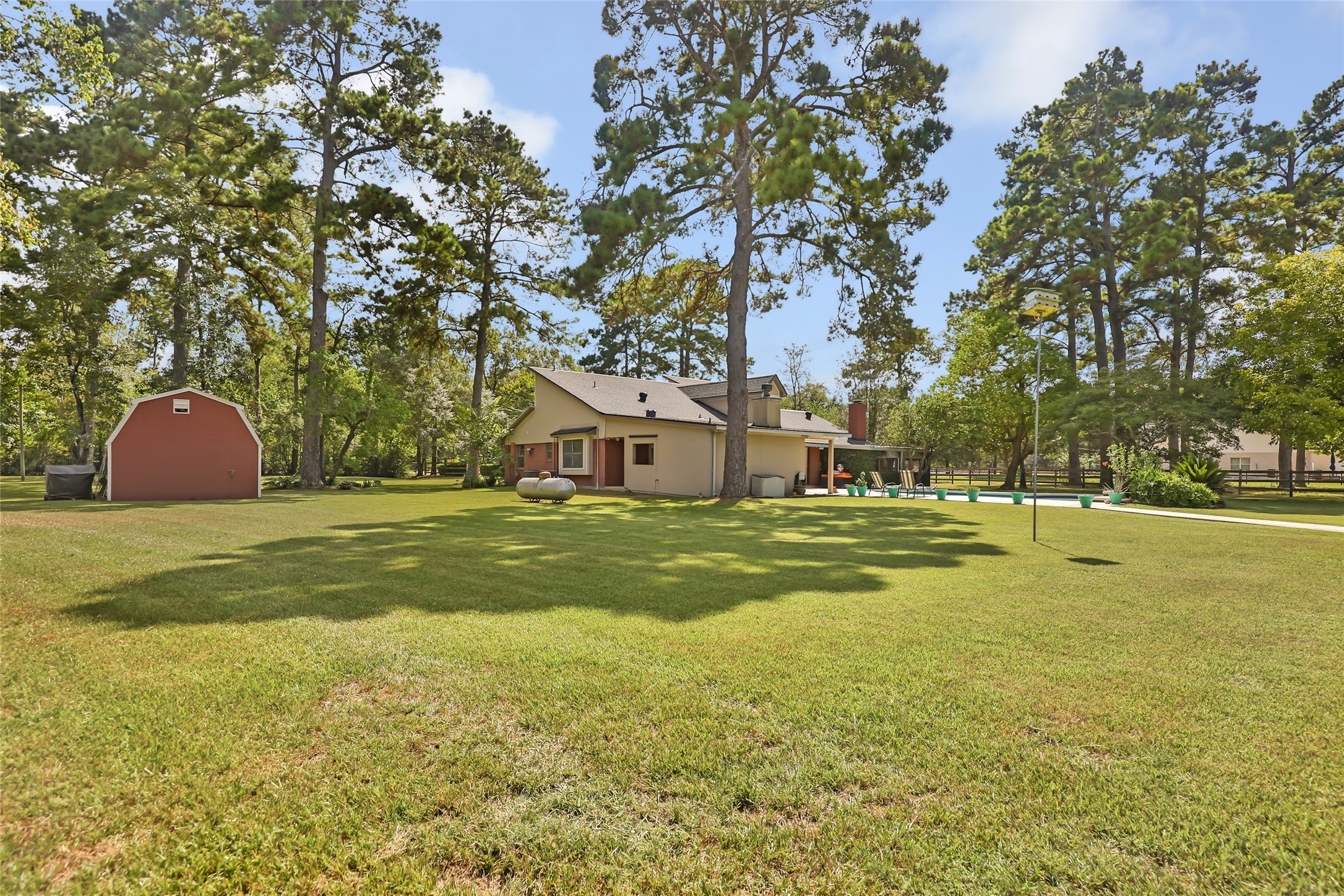 1300 Smith Road Huffman, TX 77336 - Photo 15 of 50 Spacious backyard with a convenient storage building, perfect for outdoor activities and extra space.