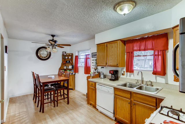 145 South Pinecrest Road Bolingbrook, IL 60440 - Photo 5 of 17 a kitchen with stainless steel appliances granite countertop a sink dishwasher a dining table and chairs with wooden floor