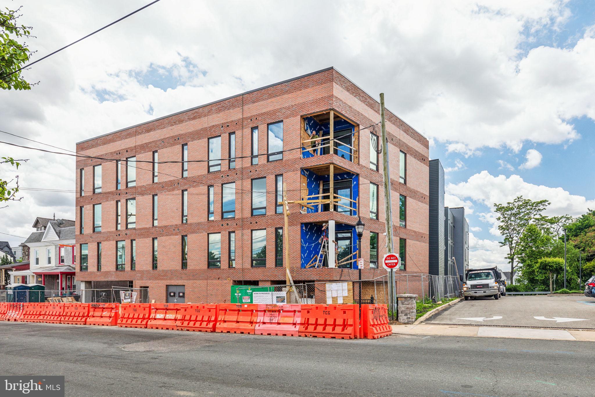 6910 Ridge Avenue, Unit 303 Philadelphia, PA 19128 - Photo 21 of 23 a city street lined with tall buildings and a yard