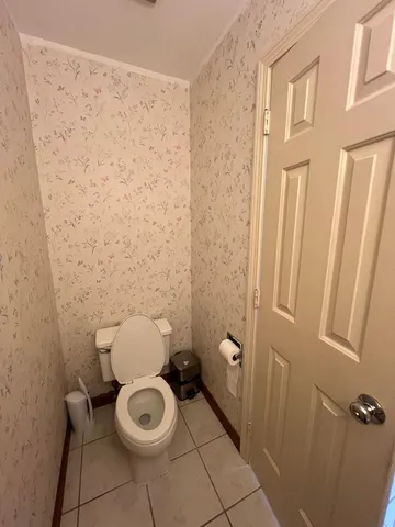 a white toilet sitting next to a shower curtain
