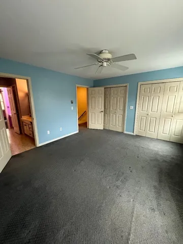 en empty room with windows and ceiling fan