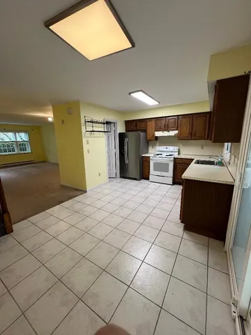 a large kitchen with a stove a sink dishwasher and a refrigerator