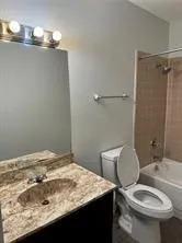 a bathroom with a sink vanity mirror and toilet