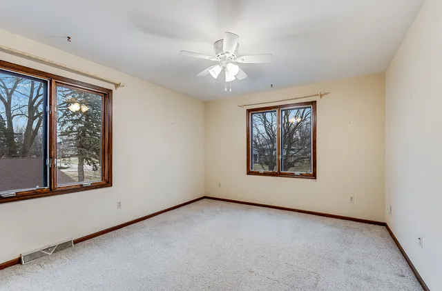an empty room with a window and a ceiling fan