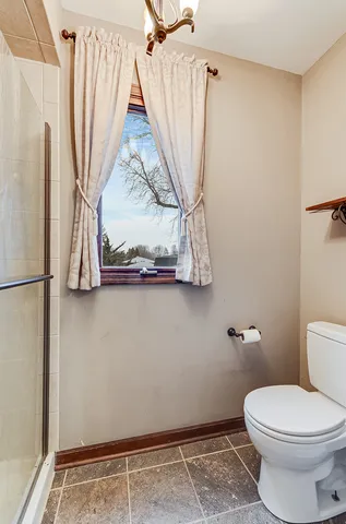 a bathroom with a toilet and a shower