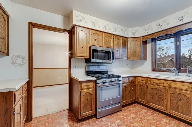 a kitchen with stainless steel appliances granite countertop a stove top oven a sink and dishwasher