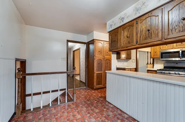 a kitchen with stainless steel appliances granite countertop a refrigerator and microwave