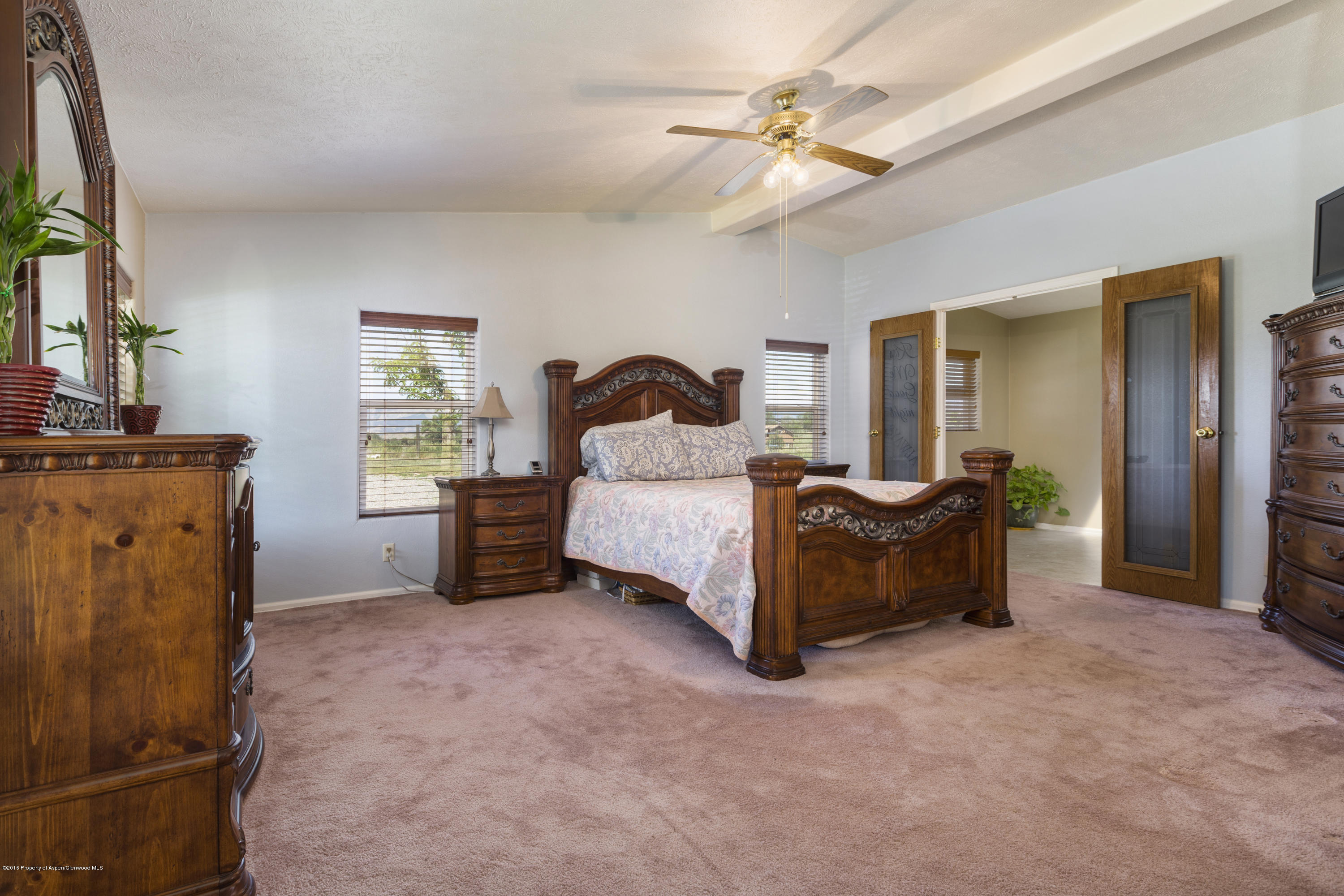 630 Lariat Road Silt, CO 81652 - Photo 13 of 21 a spacious bedroom with a bed and a chandelier