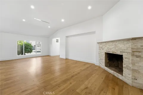 an empty room with floor to ceiling window and fireplace