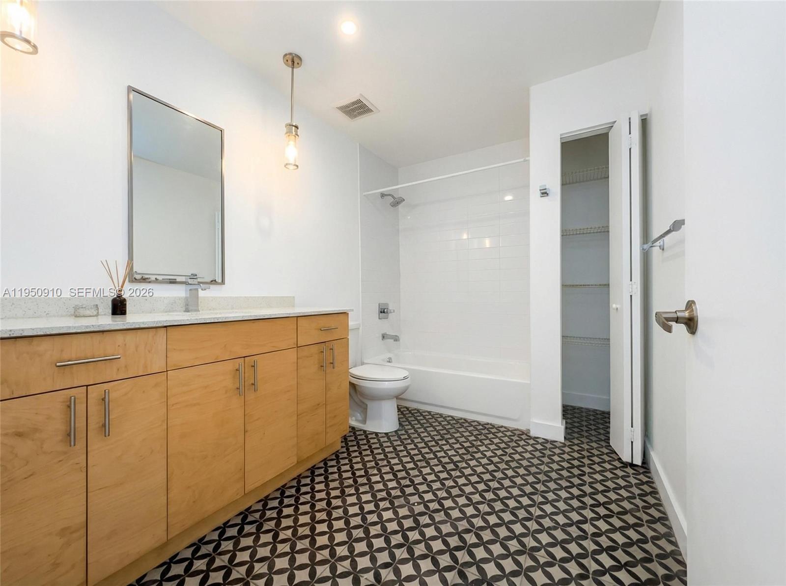 771 Northwest 1st Street, Unit 302 Miami, FL 33128 - Photo 9 of 18 a bathroom with a double vanity sink toilet and shower