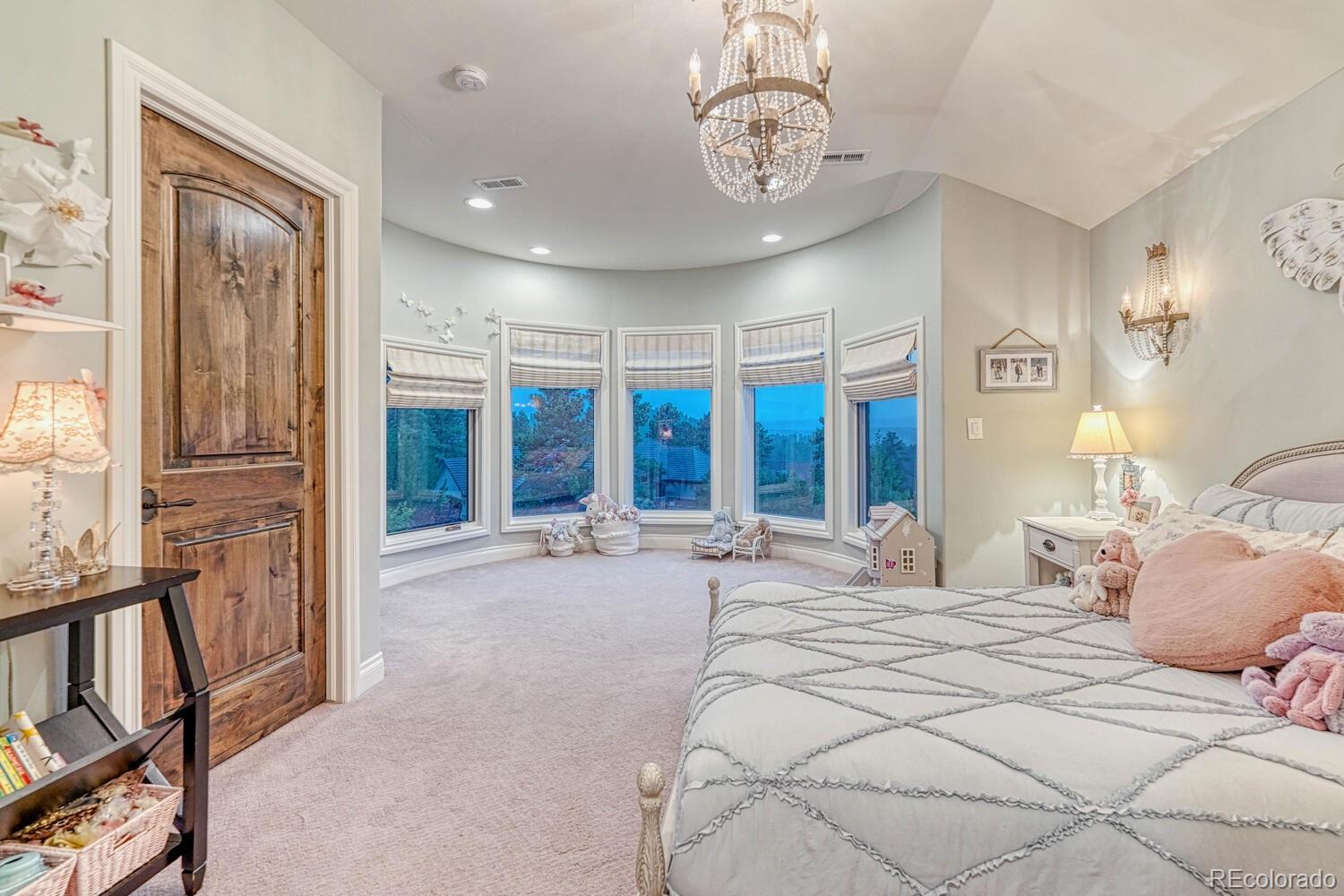 2236 Beechnut Place Castle Rock, CO 80108 - Photo 29 of 40 a bedroom with a large bed and a chandelier