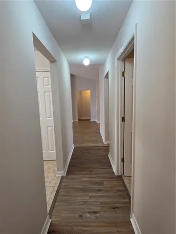 a view of a hallway with wooden floor