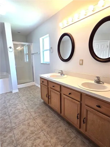 a spacious bathroom with a double vanity sink and a mirror