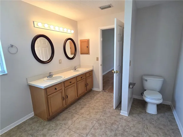 a bathroom with a toilet sink and a mirror