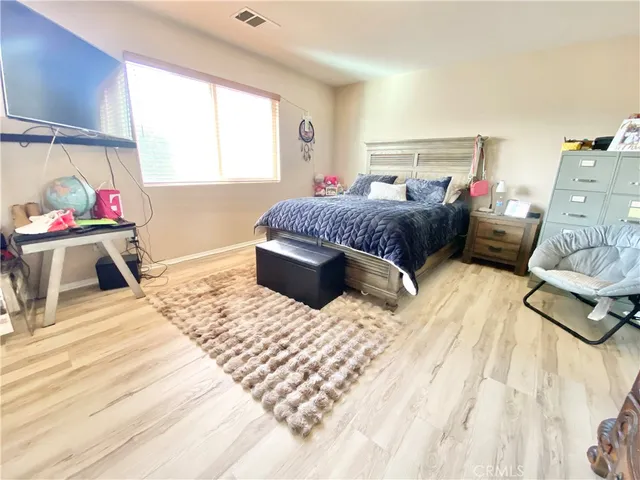 a bedroom with a bed and wooden floor