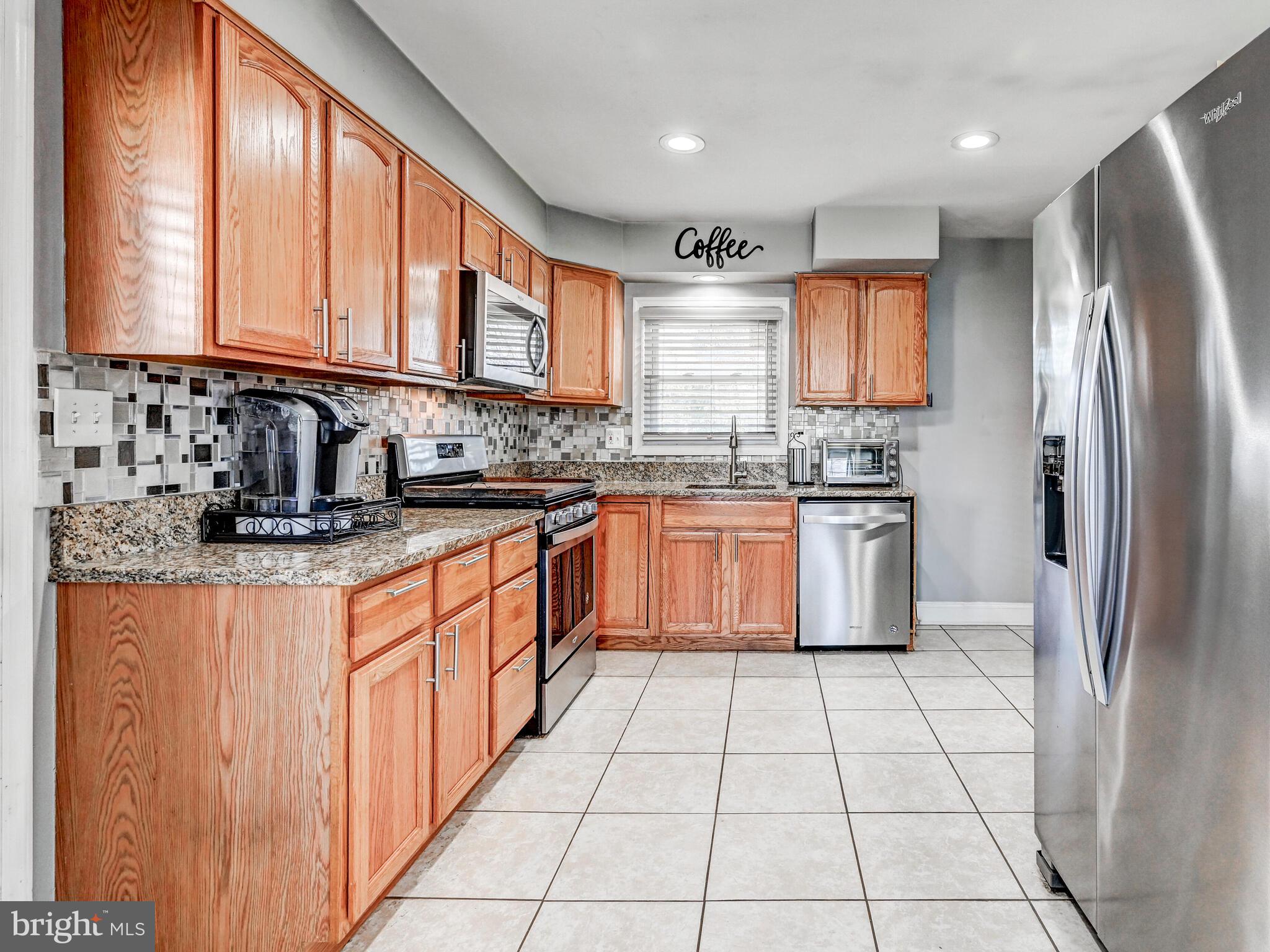 2712 Burridge Road Baltimore, MD 21234 - Photo 14 of 32 a kitchen with stainless steel appliances granite countertop a sink counter space cabinets and a large window