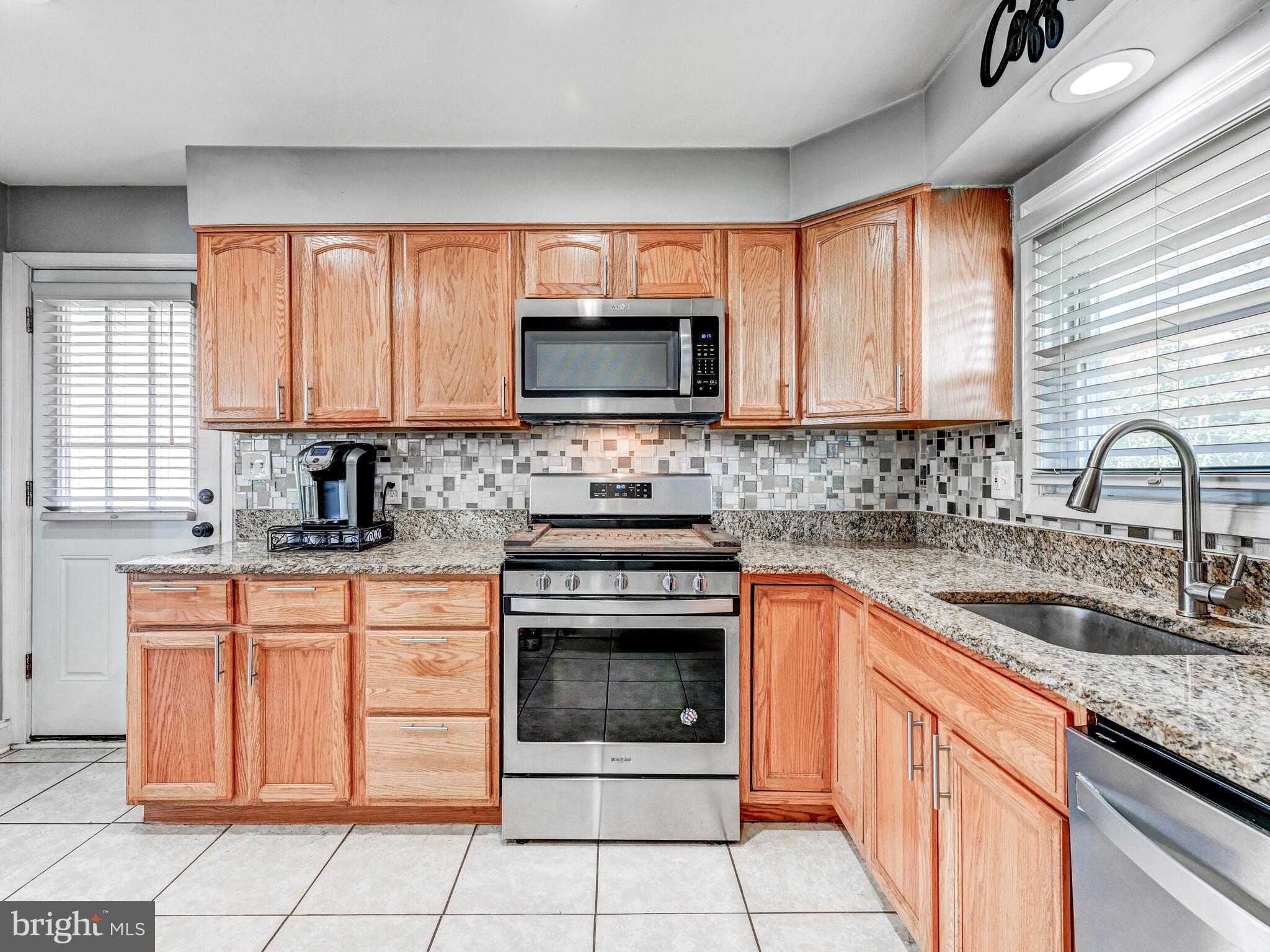 2712 Burridge Road Baltimore, MD 21234 - Photo 16 of 32 a kitchen with granite countertop a stove sink and microwave
