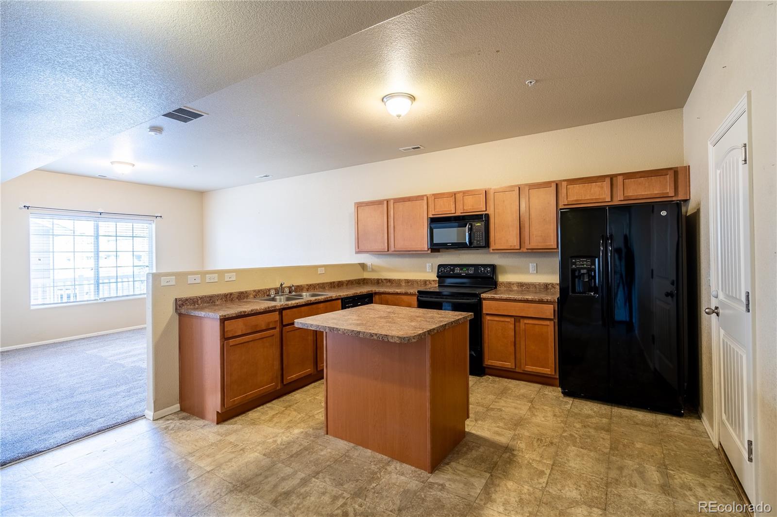 4910 Pearl Kite View Colorado Springs, CO 80916 - Photo 6 of 16 a kitchen with stainless steel appliances granite countertop a stove top oven a refrigerator a sink and a microwave