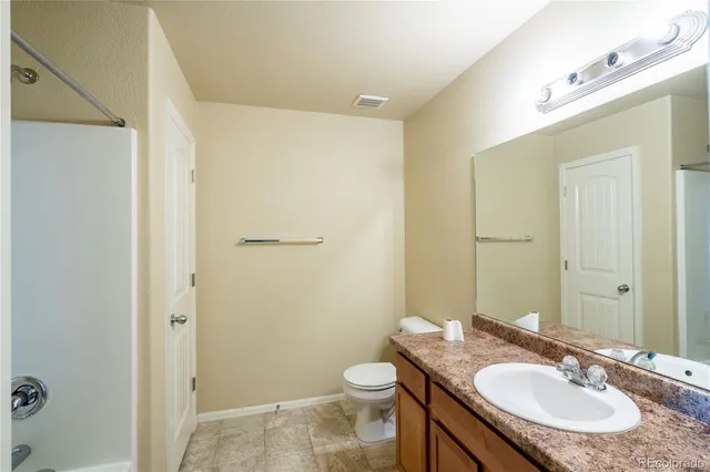 a bathroom with a granite countertop sink mirror and a bath tub