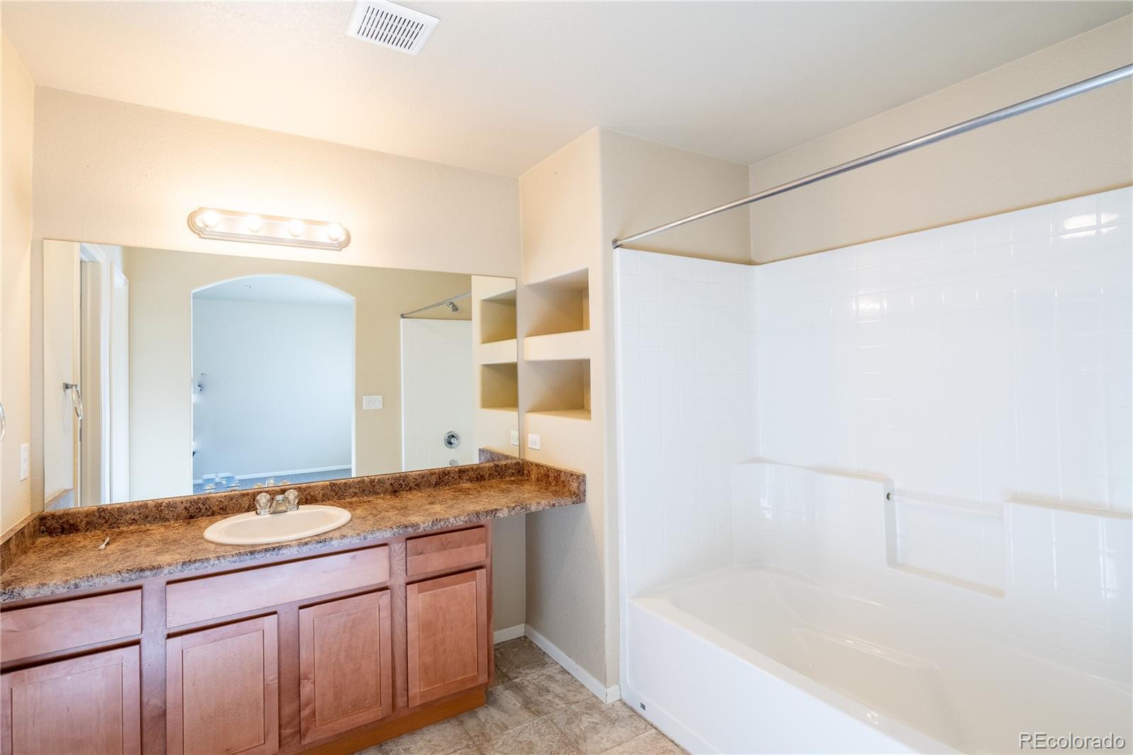 4910 Pearl Kite View Colorado Springs, CO 80916 - Photo 9 of 16 a bathroom with a granite countertop sink mirror and a bath tub