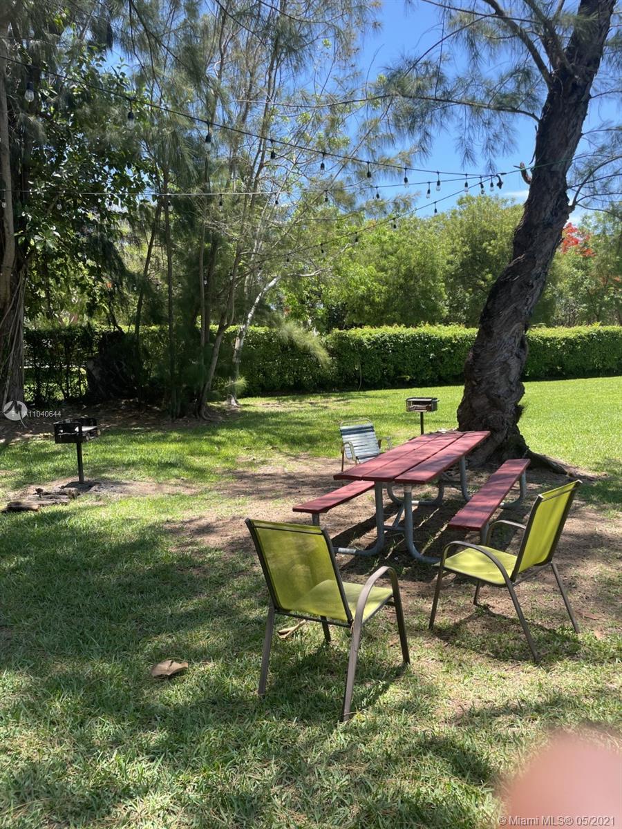 6709 North Kendall Drive, Unit 222 Pinecrest, FL 33156 - Photo 16 of 23 a backyard of a house with table and chairs