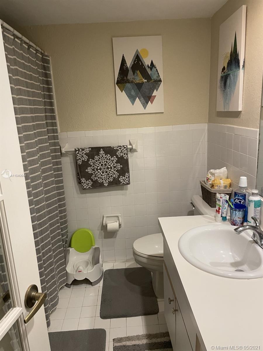 6709 North Kendall Drive, Unit 222 Pinecrest, FL 33156 - Photo 9 of 23 a bathroom with a sink a toilet and a mirror