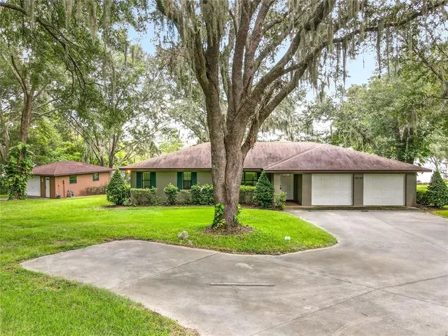 a front view of a house with a garden and trees