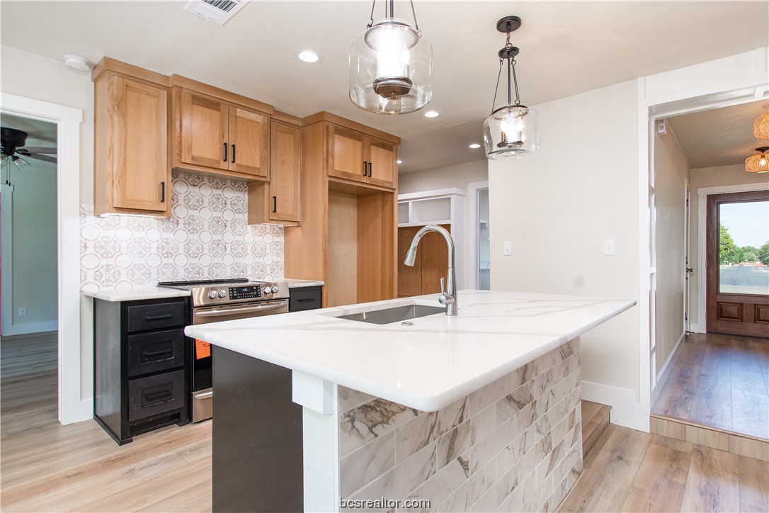 a open kitchen with stainless steel appliances granite countertop a sink a stove and a refrigerator