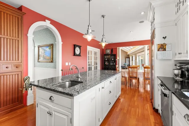 a kitchen with stainless steel appliances granite countertop a stove a sink and a wooden floors