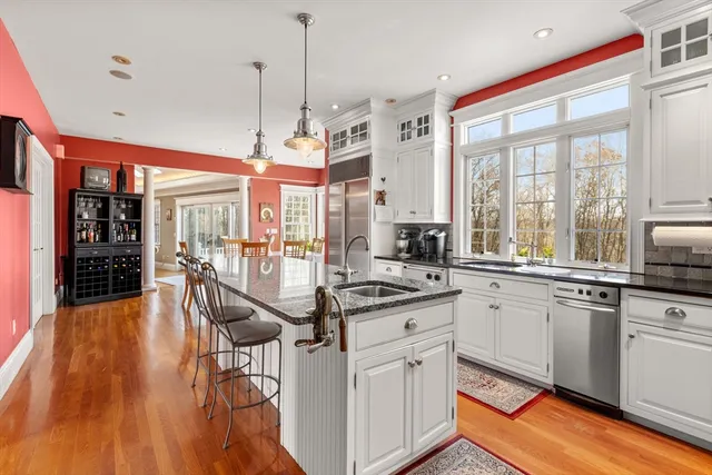 a kitchen with stainless steel appliances granite countertop a stove and white cabinets