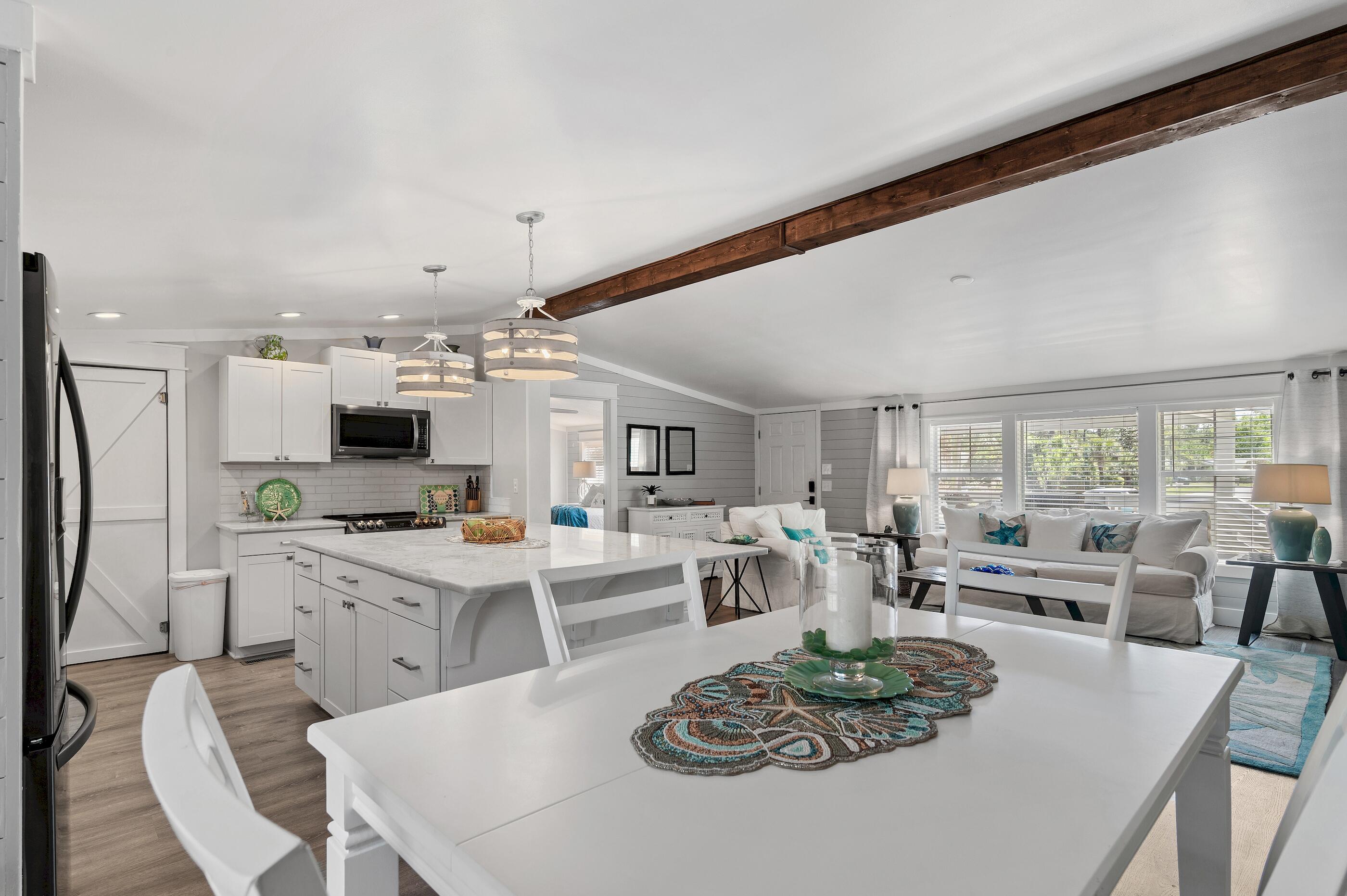 301 Edgewood Terrace Santa Rosa Beach, FL 32459 - Photo 13 of 34 a living room with stainless steel appliances furniture a table and chairs