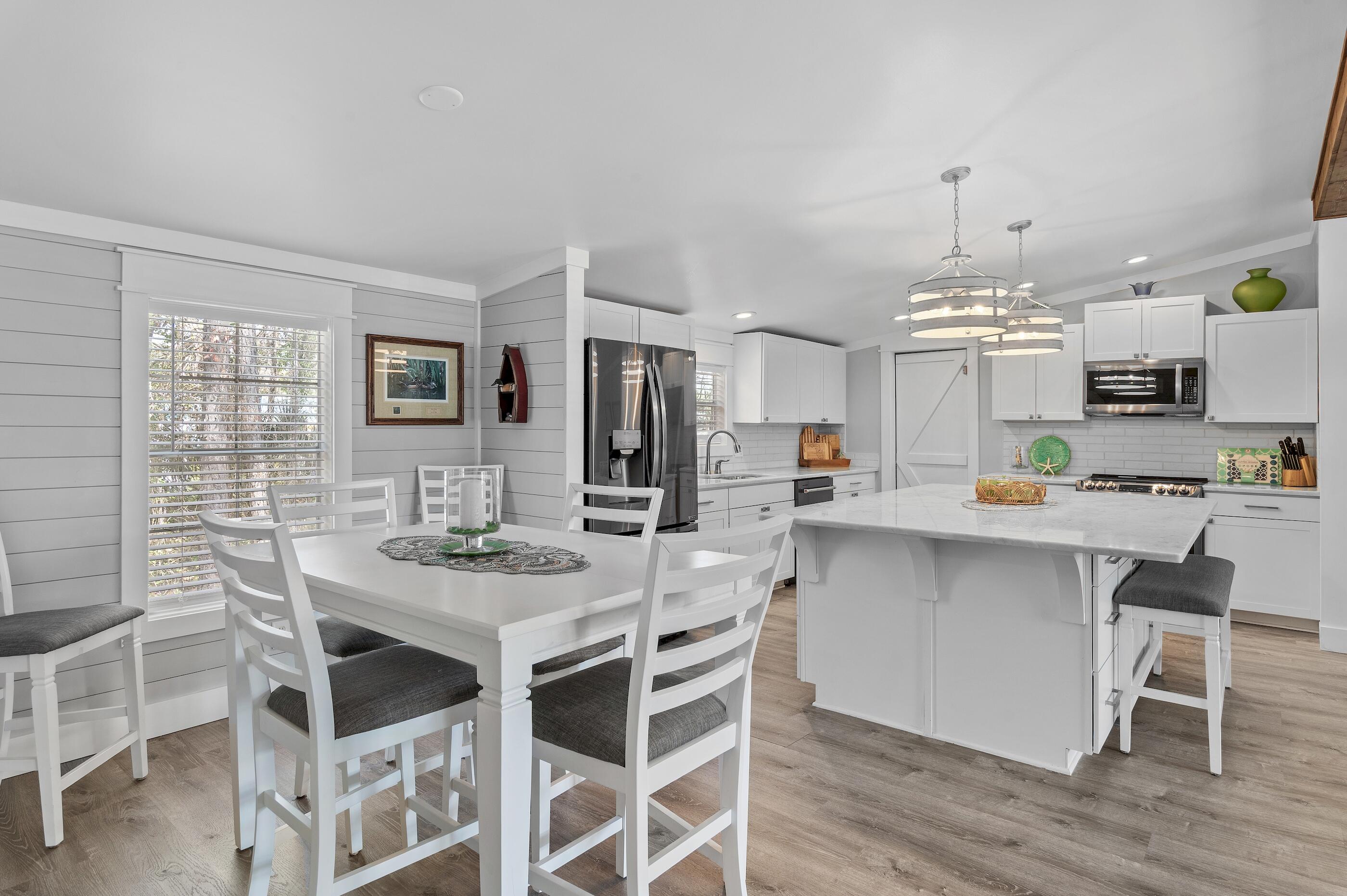 301 Edgewood Terrace Santa Rosa Beach, FL 32459 - Photo 9 of 34 a kitchen with stainless steel appliances kitchen island granite countertop a dining table chairs and granite counter tops