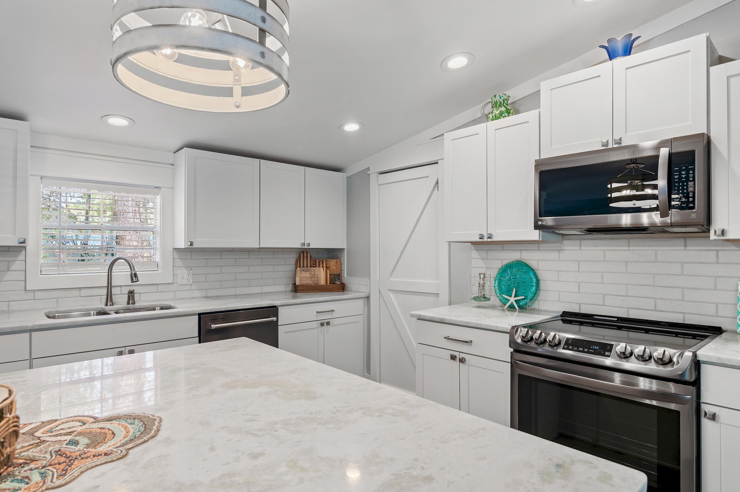 301 Edgewood Terrace Santa Rosa Beach, FL 32459 - Photo 10 of 34 a kitchen with stainless steel appliances a stove a sink and a microwave