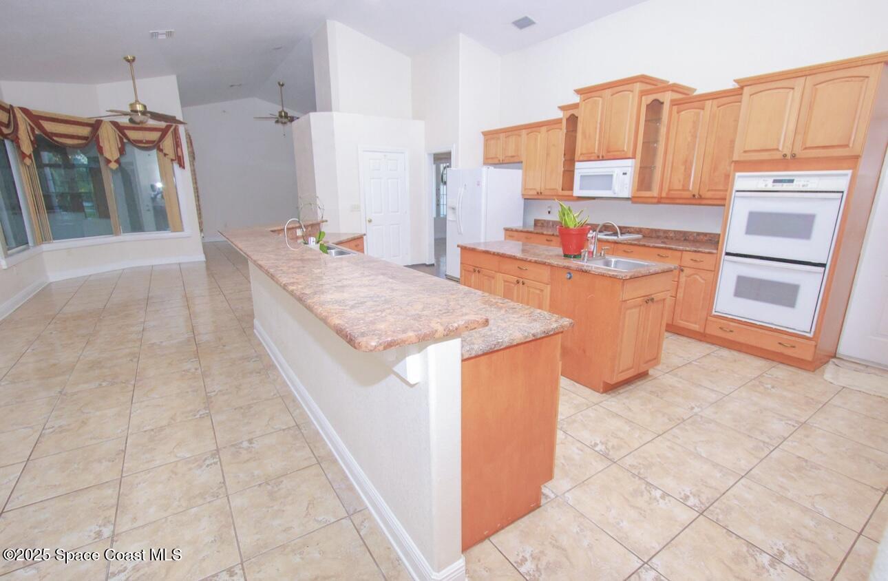 1857 Timbers W Boulevard Rockledge, FL 32955 - Photo 16 of 44 a kitchen with stainless steel appliances granite countertop a stove a sink and a refrigerator
