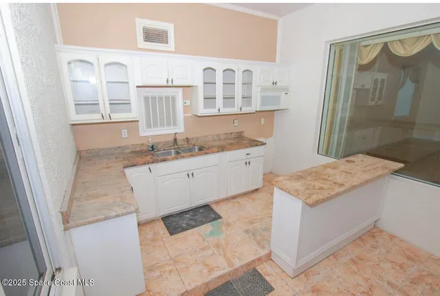 a bathroom with a granite countertop sink a mirror and shower