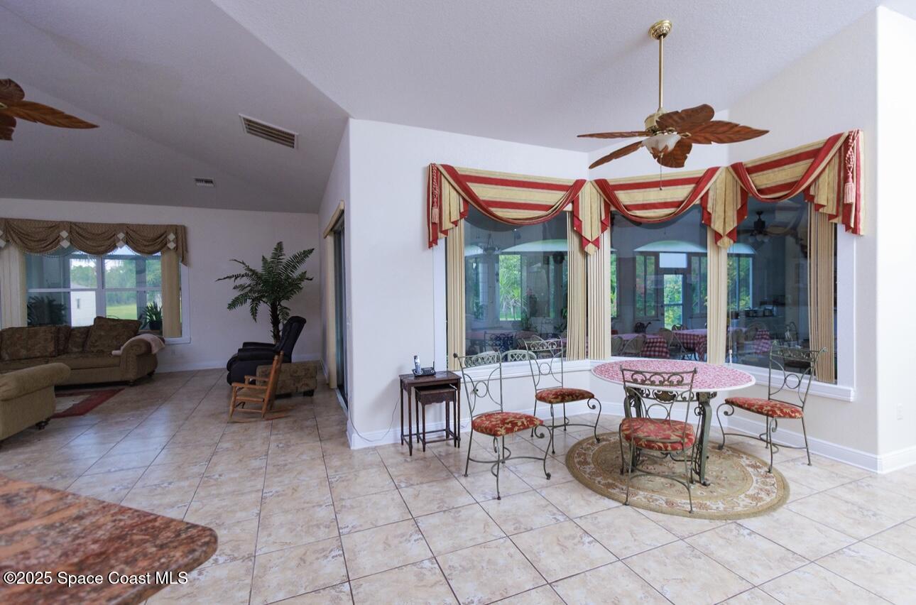 1857 Timbers W Boulevard Rockledge, FL 32955 - Photo 10 of 44 a living room with furniture a chandelier and a large window