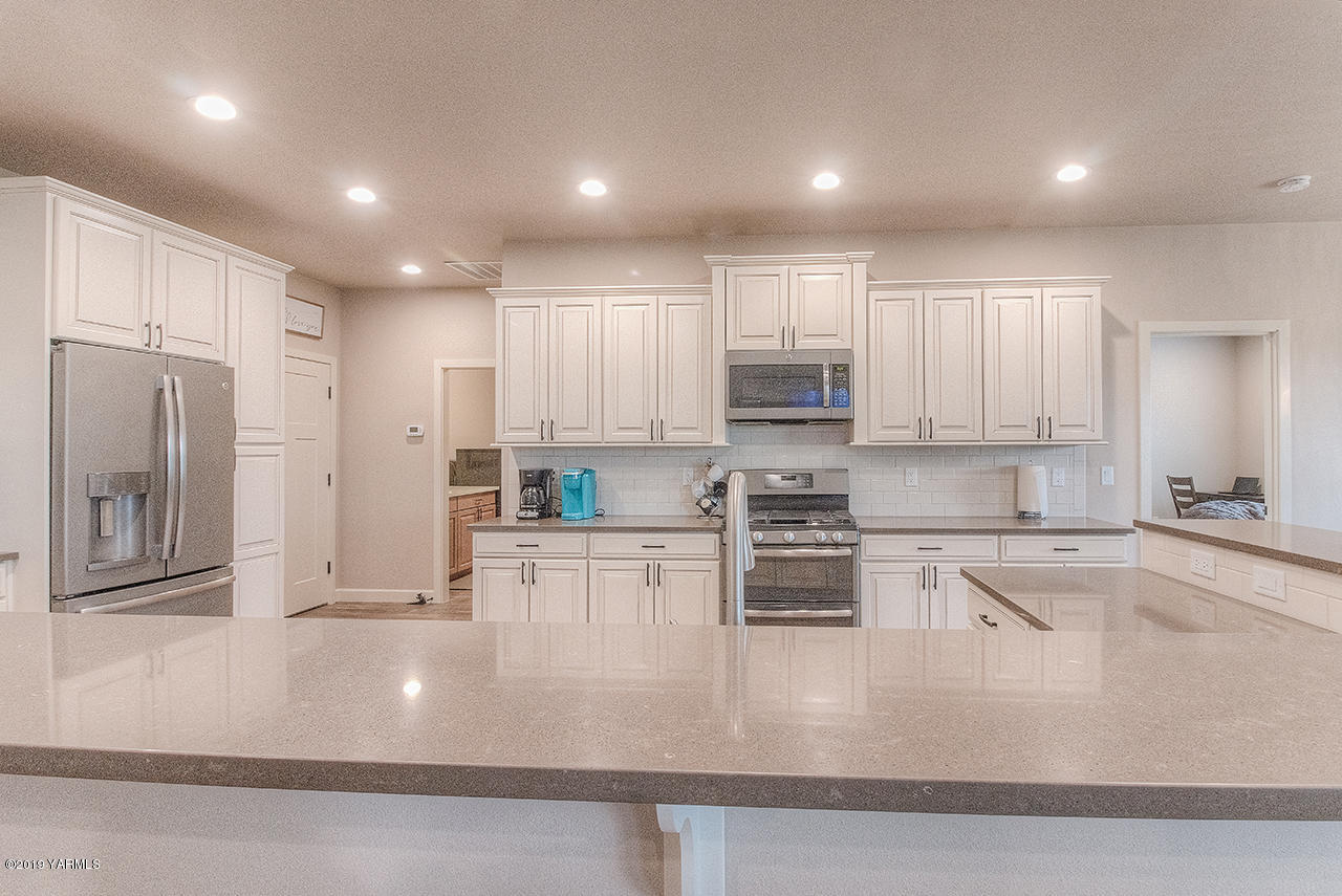 9202 Coolidge Road Yakima, WA 98903 - Photo 10 of 45 a kitchen with stainless steel appliances granite countertop a refrigerator sink and white cabinets