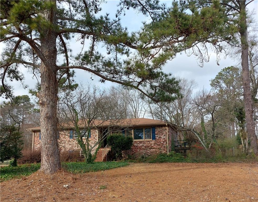 1803 Hasty Road Marietta, GA 30062 - Photo 2 of 23 a view of a white house next to a yard with large trees