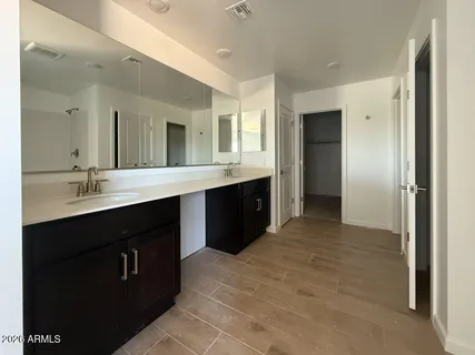 a spacious bathroom with a double vanity sink and mirror