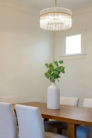 a kitchen with stainless steel appliances granite countertop a stove a sink a oven a dining table and chairs with wooden floor