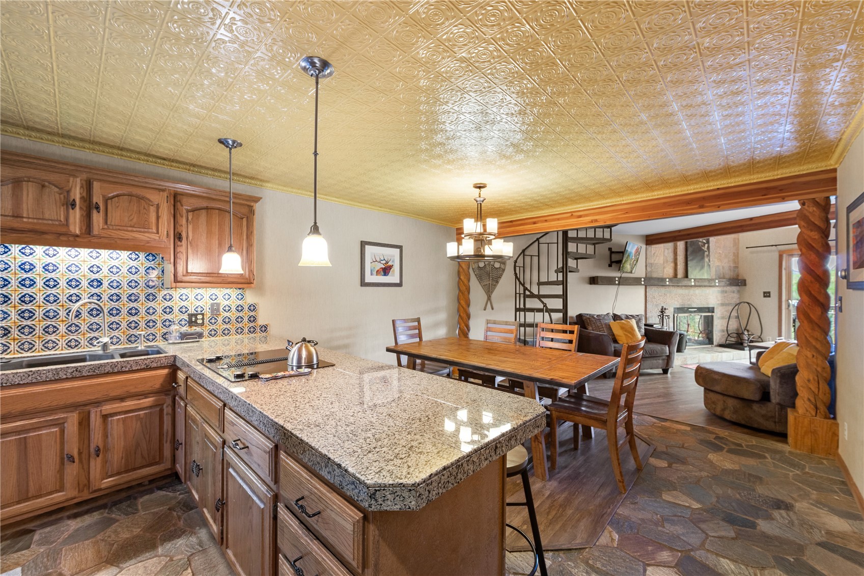 9490 Ryan Gulch Road, Unit 94202 Silverthorne, CO 80498 - Photo 12 of 50 a kitchen with a stove a sink dishwasher a kitchen island with chairs and wooden cabinets