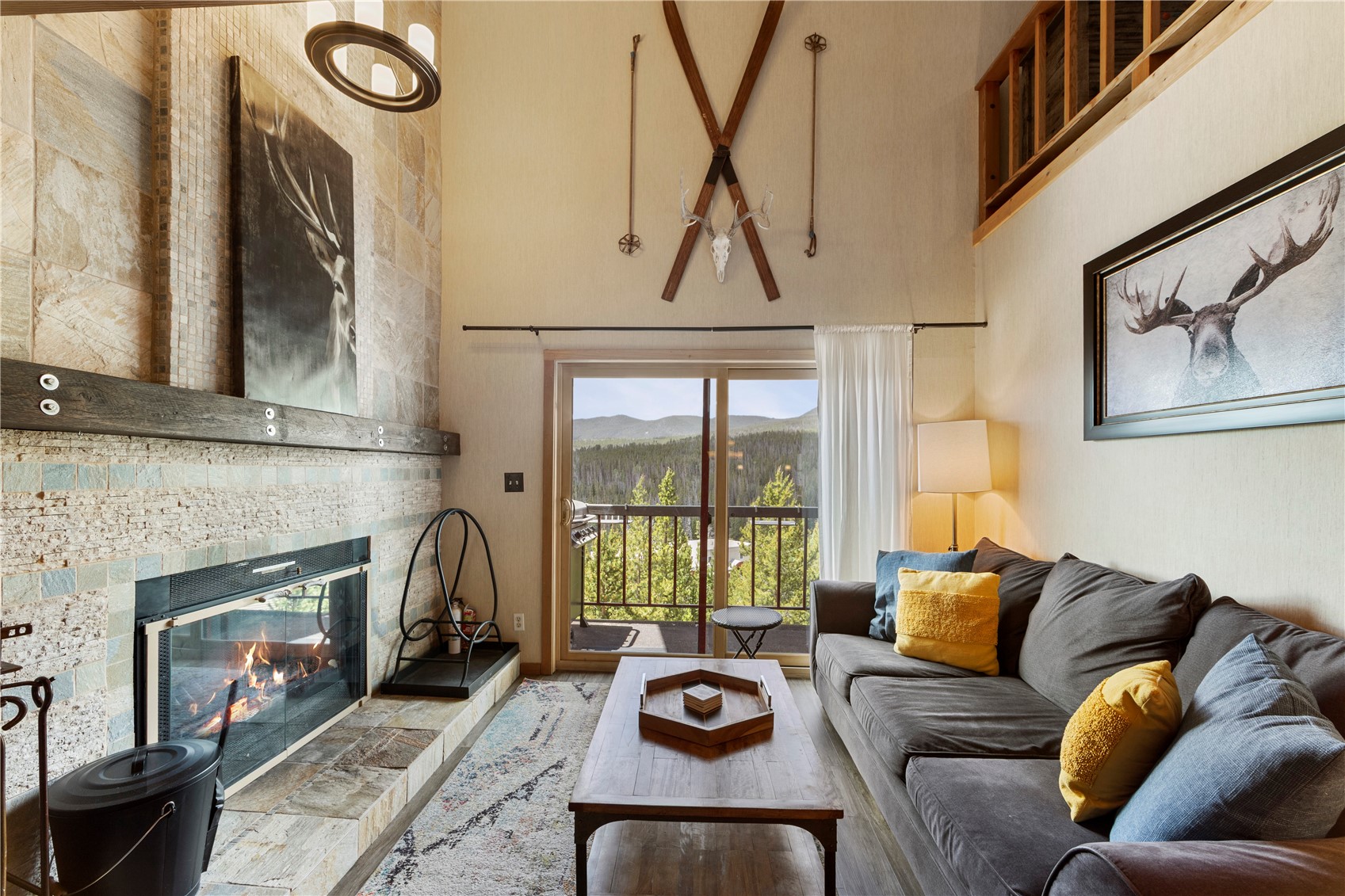 9490 Ryan Gulch Road, Unit 94202 Silverthorne, CO 80498 - Photo 19 of 50 a living room with furniture a fireplace and a floor to ceiling window