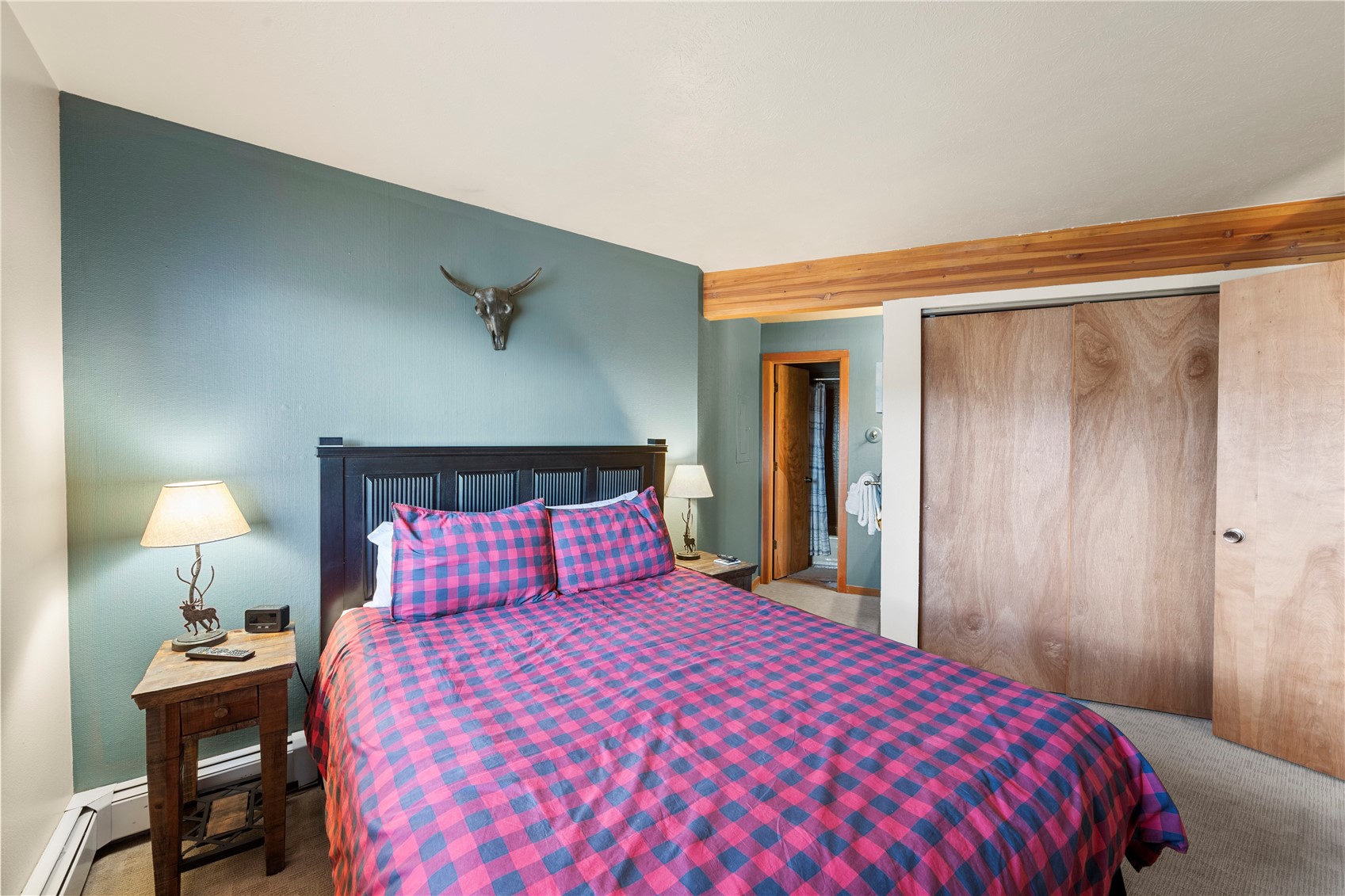 9490 Ryan Gulch Road, Unit 94202 Silverthorne, CO 80498 - Photo 23 of 50 a bedroom with a bed and a lamp on table