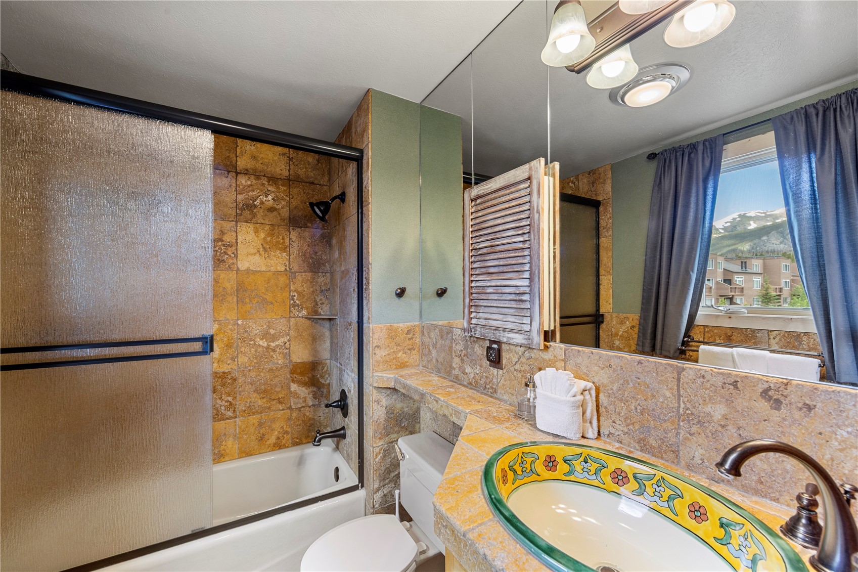 9490 Ryan Gulch Road, Unit 94202 Silverthorne, CO 80498 - Photo 31 of 50 a bathroom with a granite countertop sink mirror vanity and a bathtub