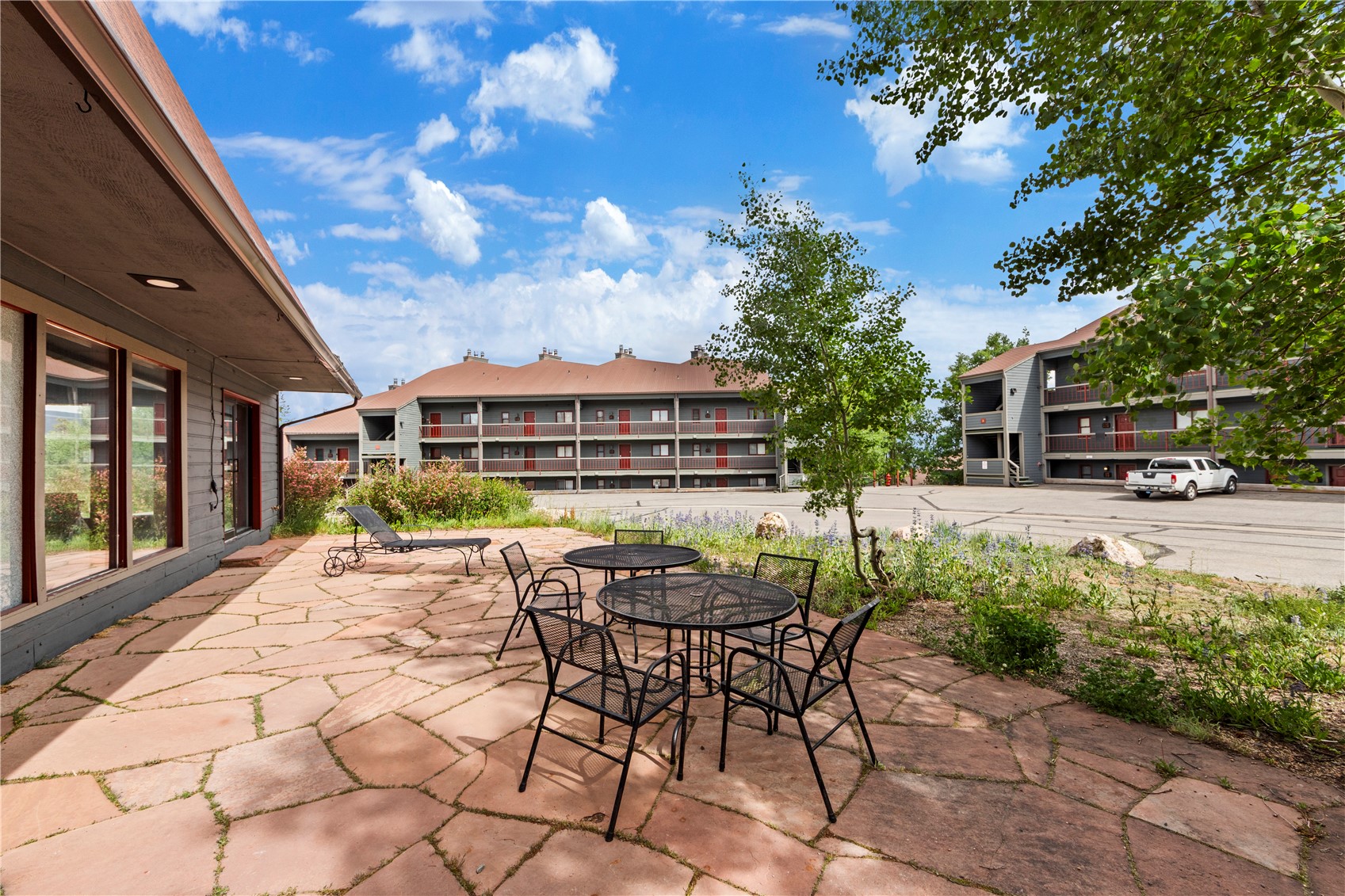 9490 Ryan Gulch Road, Unit 94202 Silverthorne, CO 80498 - Photo 36 of 50 a view of a patio with table and chairs with wooden fence and plants