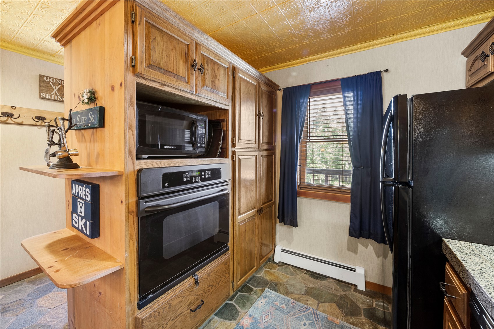 9490 Ryan Gulch Road, Unit 94202 Silverthorne, CO 80498 - Photo 9 of 50 a kitchen with stainless steel appliances granite countertop a refrigerator a stove and a sink with wooden cabinets
