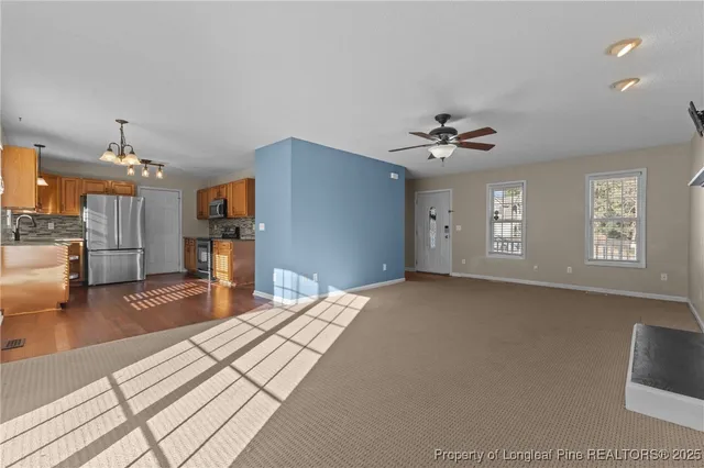 a view of an empty room with a fireplace and a window