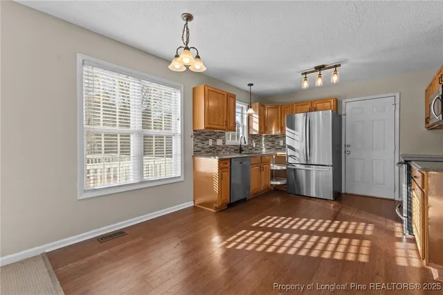 a kitchen with granite countertop a refrigerator and a sink